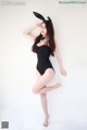 A woman in a black bathing suit posing for a picture.