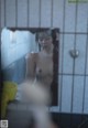 A naked woman taking a shower in a bathroom.