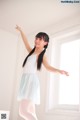 A young woman in a white and blue dress is dancing.