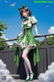 A woman in a green and white dress standing on a bridge.