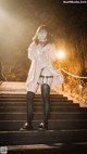 A woman in lingerie and stockings standing on a set of stairs.