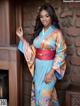 A woman in a blue and orange kimono posing for a picture.